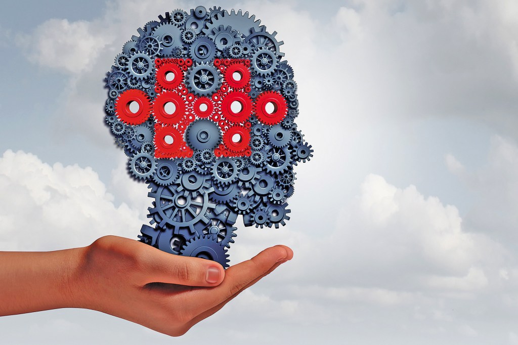 A hand that holds a set of gear objects and cogs formed as a human head with a part of the puzzle of jigsaw as a symbol of teaching technology with 3D illustration elements.